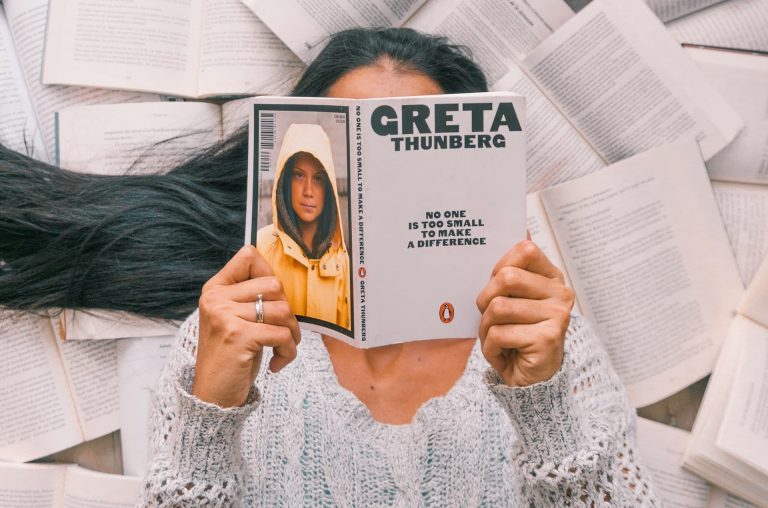 Girl reads a book by Greta Thunberg.